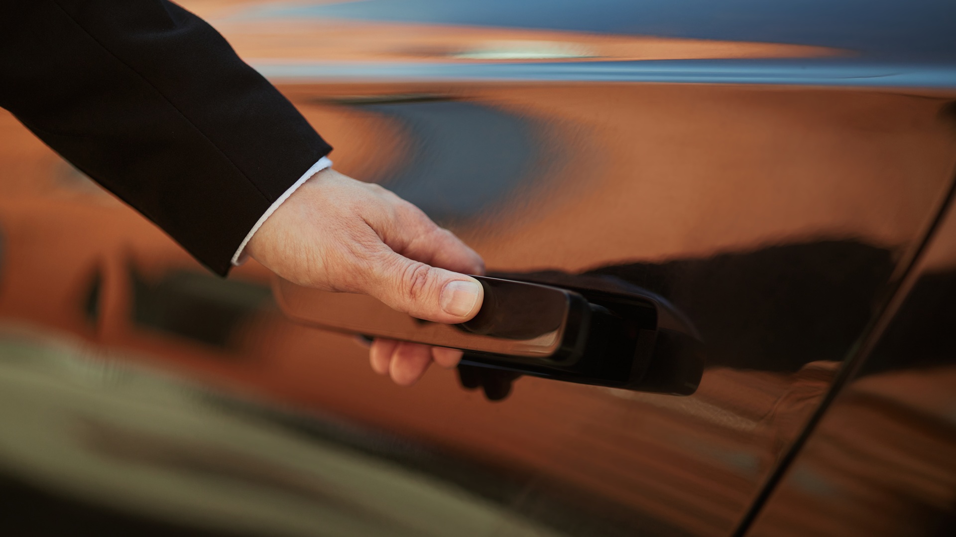 envato-hand-in-a-suit-opening-a-luxury-car-door-at-sunset-2026-08-19-23-13-17-utc