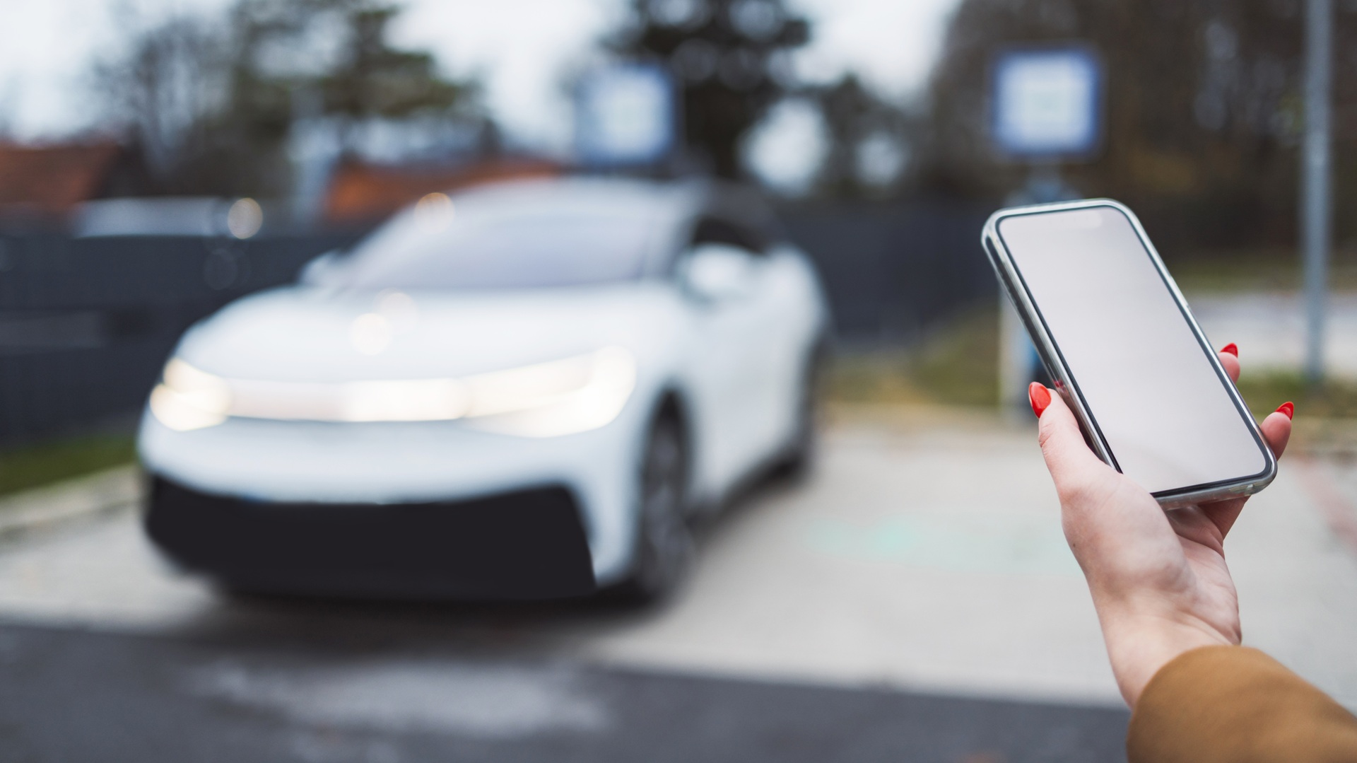 woman-using-mobile-phone-near-electric-car-2026-03-18-04-34-35-utc